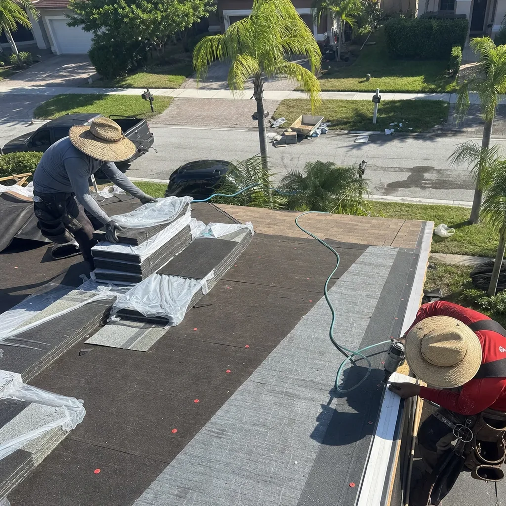 Roofers performing professional residential roof replacement and shingle installation.